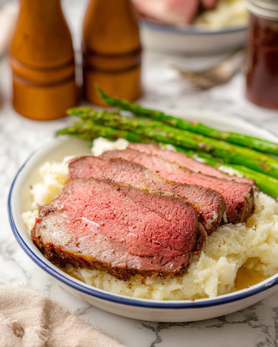 Three thick slices of medium-rare roast beef with a pink center and browned edges lie on top of a layer of creamy white mashed potatoes with a slightly chunky texture. Bright green asparagus stalks are placed behind the beef, adding a fresh and vibrant contrast. All the food is arranged on a white plate with a blue rim, set on a white marbled surface. In the blurry background, there are wooden salt and pepper grinders and a brown jar, along with a folded cloth napkin. photo taken with an iphone --ar 4:5 --v 7
