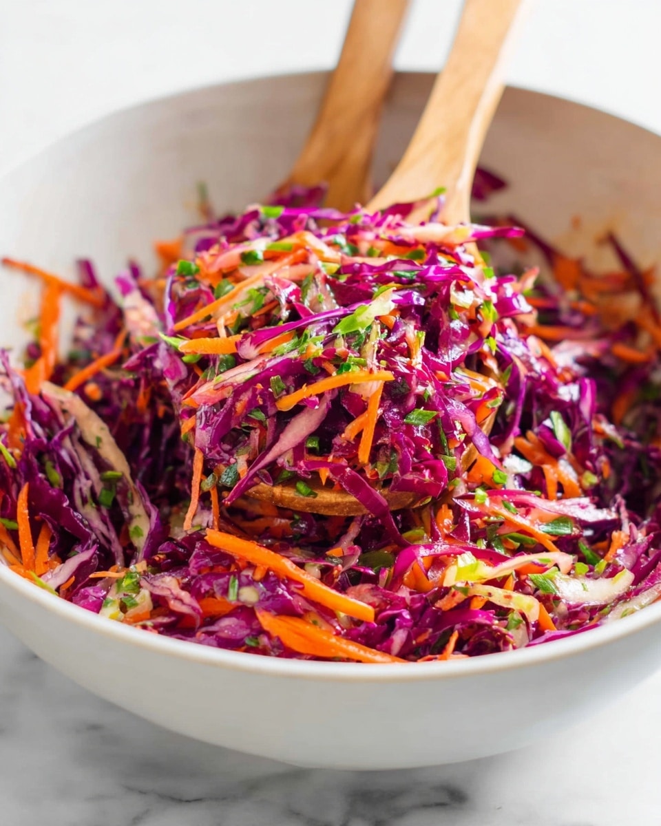 A white bowl filled with a colorful mix of shredded purple cabbage and thin orange carrot strips, finely chopped green herbs scattered throughout, creating a fresh and vibrant texture. Two wooden spoons lift the salad, showing its light and crunchy layers with a mix of thin purple, bright orange, and green bits. The background is softly blurred with a white marbled texture. photo taken with an iphone --ar 4:5 --v 7