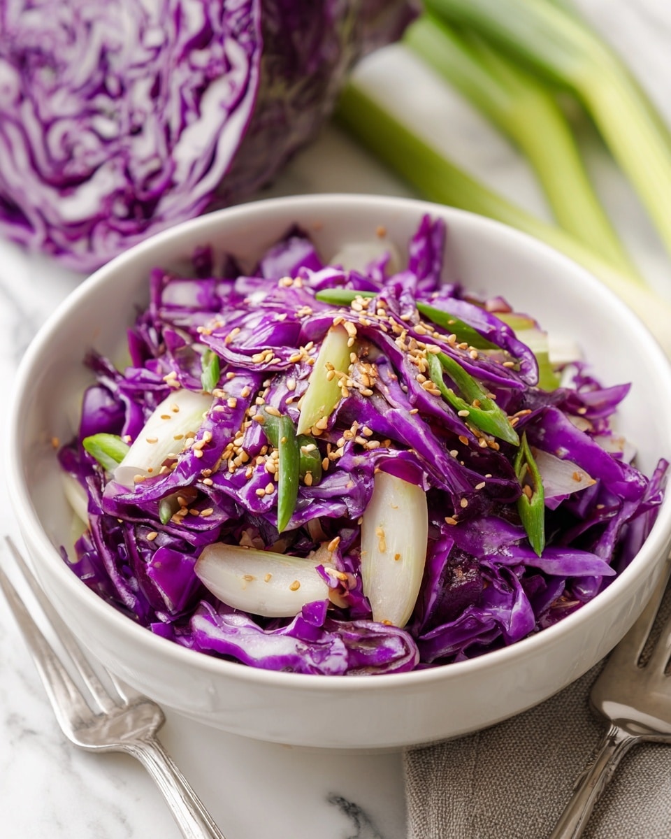 A bowl filled with thinly sliced bright purple cabbage mixed with light green celery sticks and sprinkled with small white sesame seeds and chopped green onions on top. The bowl is white and placed on a white marbled surface with pieces of purple cabbage and whole celery stalks next to it. Two silver forks and a dark gray cloth are placed near the bowl. The colors are fresh and vibrant with a clean, simple look. Photo taken with an iphone --ar 4:5 --v 7