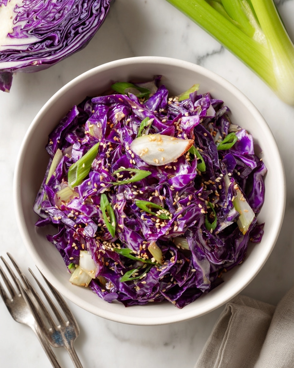 A bowl filled with a purple cabbage salad shows multiple layers: the base layer is thin, bright purple cabbage strips with a shiny, fresh texture; mixed in are pale white celery slices adding a slight crunch; the top is sprinkled with small, tan sesame seeds and chopped bright green onion pieces for color contrast; the bowl is white, placed against a white marbled surface with some celery stalks and cabbage halves nearby, two silver forks rest beside the bowl. Photo taken with an iphone --ar 4:5 --v 7