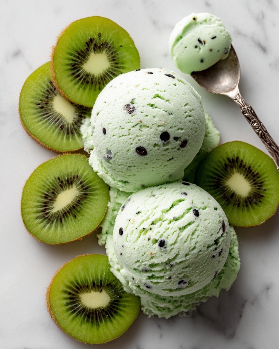 The image shows three smooth, round scoops of light green kiwi ice cream with small black kiwi seeds scattered throughout. The scoops have a soft, creamy texture and are placed closely together. Around the ice cream are thin slices of kiwi fruit, showing the bright green flesh and dark seeds in the center. The background is a white marbled texture, giving a clean and fresh look. photo taken with an iphone --ar 4:5 --v 7
