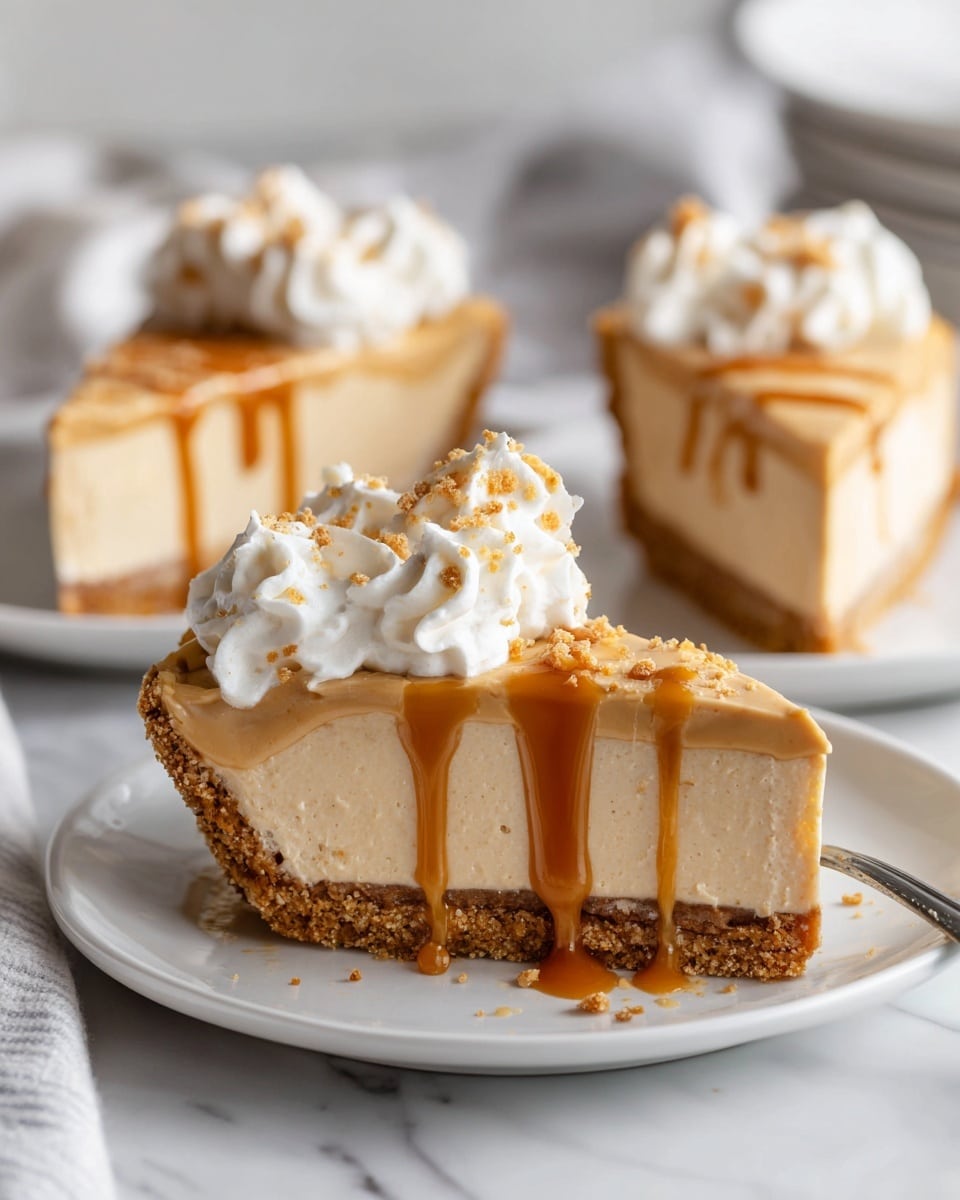 The image shows slices of a creamy peanut butter pie on a white plate placed on a white marbled surface. Each slice has three visible layers: a pale brown crust at the bottom, a thick light brown creamy peanut butter filling in the middle, and a thin drizzle of darker caramel-colored sauce on top. A small swirl of white whipped cream sits center-top on each slice, sprinkled lightly with brown crumbs. Photo taken with an iphone --ar 4:5 --v 7